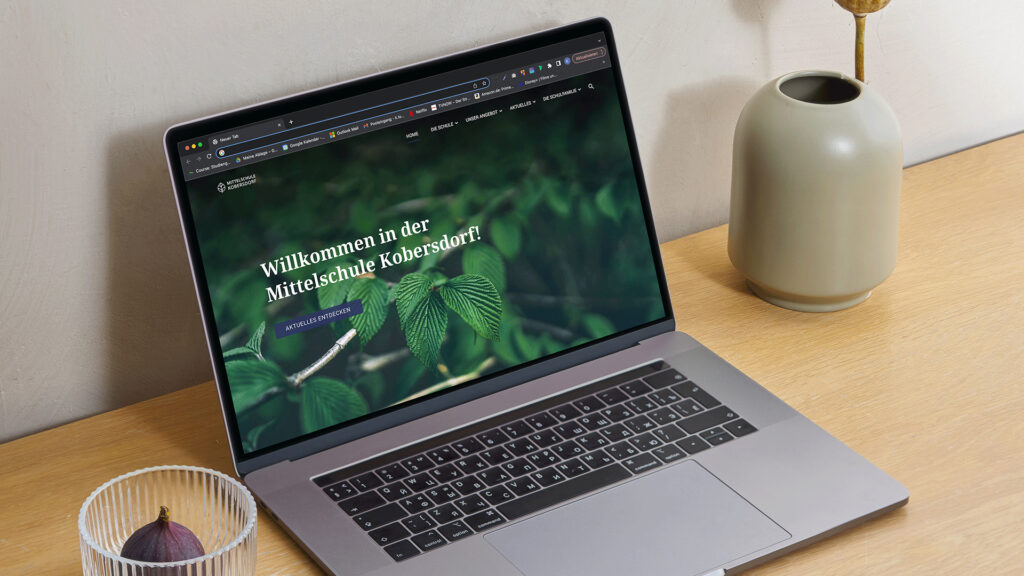 Mittelschule Kobersdorf Teaserbild Mittelschule Kobersdorf Website auf einem Laptop auf einem Schreibtisch